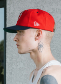 Man wearing Pieces God vs Devil Baseball Cap Hat Red Navy with Devil logo, close up side view Pieces God vs Devil Baseball Cap Red Navy - Image 6 | Authenticated at Pieces Los Angeles
