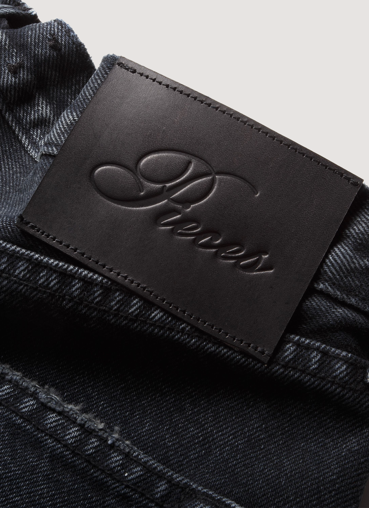 Pieces Alexander Denim Washed Black jeans close up shot of the leather back patch