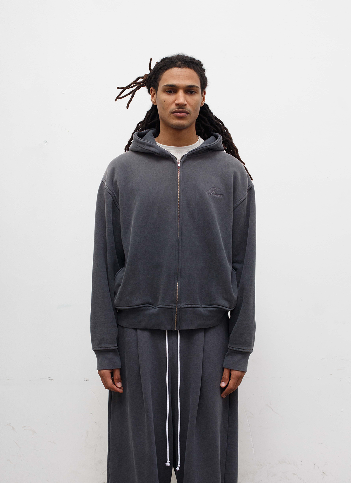 Man wearing the Pieces Basic Program Zip Up Sweatshirt Washed Black grey hoodie with zipper, front view Pieces Basic Program Zip Up Sweatshirt Washed Black - Image 3 | Authenticated at Pieces Los Angeles