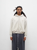 Man wearing sweatpants and the Pieces Basic Program Zip Up Sweatshirt Bone White Off-White front view Pieces Basic Program Zip Up Sweatshirt Bone - Image 3 | Authenticated at Pieces Los Angeles