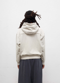 Man wearing sweatpants and the Pieces Basic Program Zip Up Sweatshirt Bone White Off-White back view Pieces Basic Program Zip Up Sweatshirt Bone - Image 4 | Authenticated at Pieces Los Angeles