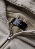 Pieces Basic Program Zip Up Sweatshirt Bone White Off-White close up view of the neck tag and zipper Pieces Basic Program Zip Up Sweatshirt Bone - Image 5 | Authenticated at Pieces Los Angeles