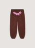 Sp5der Worldwide Cuffed Sweatpants Brown with pink graphic text and little yellow stars, front view