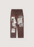 Better With Age Cambridge Carpenter Pants Brown double knee trousers, opened bottom hem, puff print logos and printed sewn on patches all over the front, front view Better With Age Cambridge Carpenter Pants Brown - Image 1 | Authenticated at Pieces Los Angeles