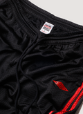 Pieces Elongated Mesh Shorts Black Red with black drawstrings, close up view of waist, drawstring, and back tag Pieces Elongated Mesh Shorts Black Red - Image 3 | Authenticated at Pieces Los Angeles