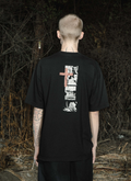Person outside in the dark wearing the Pieces Inhumane Tee Vintage Black shirt facing away from the camera Pieces Inhumane Tee Vintage Black - Image 5 | Authenticated at Pieces Los Angeles