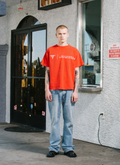 Man standing in front of store wearing the Pieces Mental Health Tee shirt Vintage Red front view Pieces Mental Health Tee Vintage Red - Image 6 | Authenticated at Pieces Los Angeles