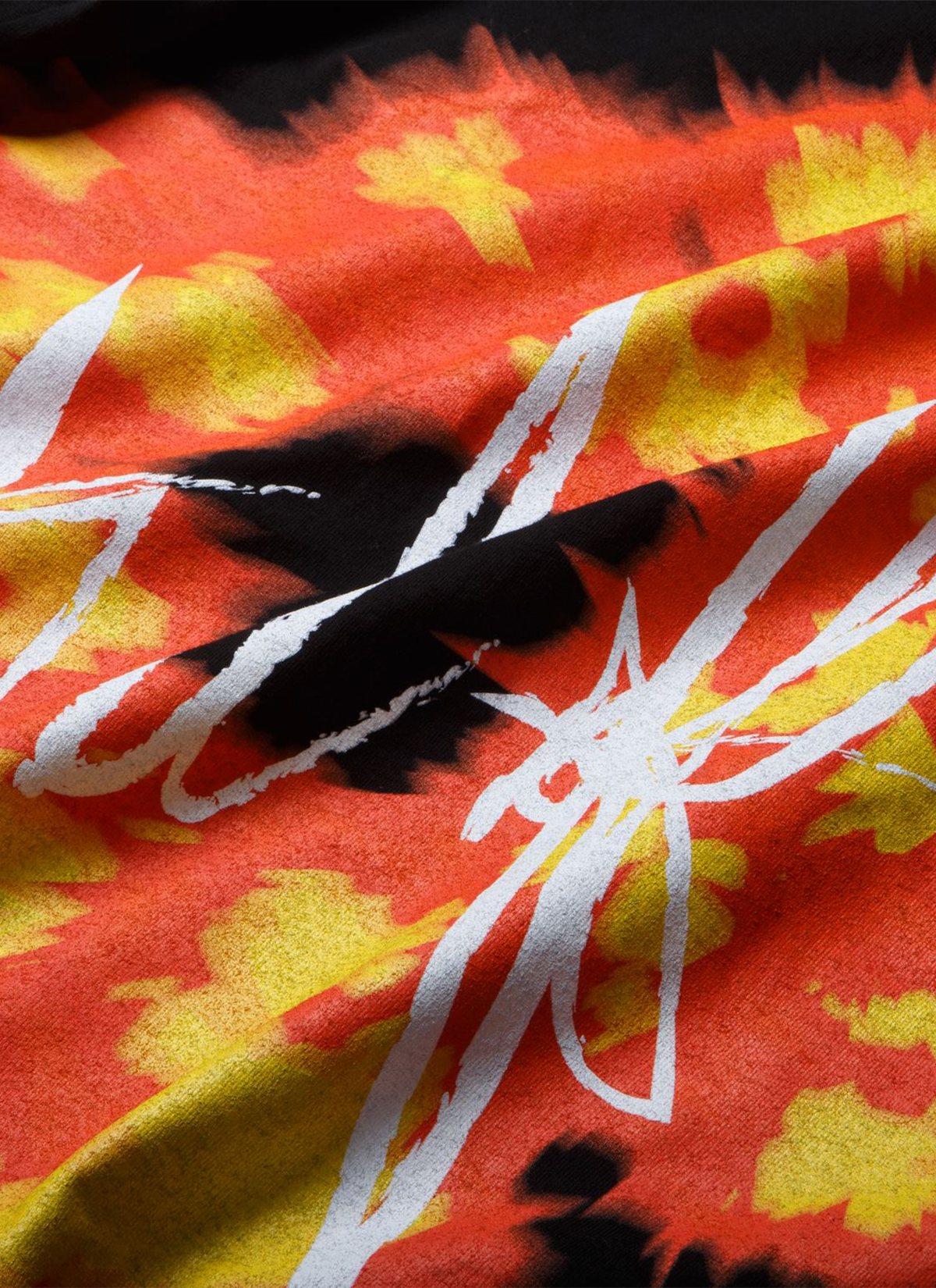 Denim Tears Offset Tee 1 Black with Orange and Yellow wreath graphic and white text, close up view of graphic