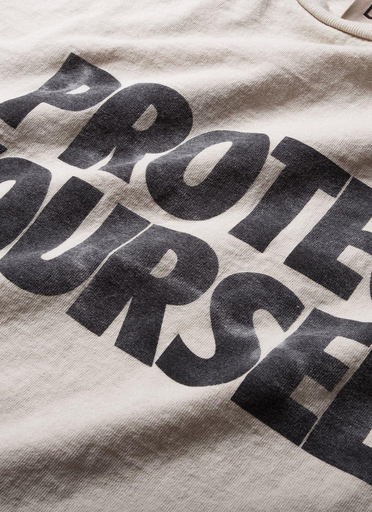 Gallery Dept. Protect Your Neck Tee Vintage White with faded black text, close up view of front