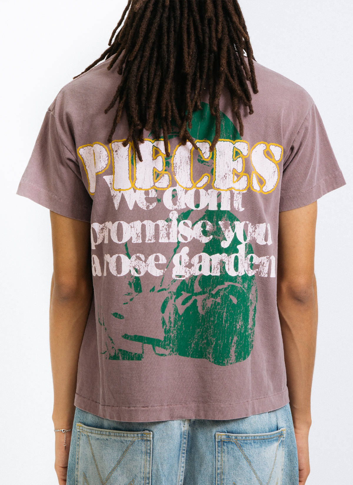 Man wearing the Pieces Rose Garden Tee Shirt Vintage Brown Stone with graphic of green soldier with white text, back view