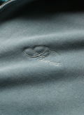 Pieces Basic Program Zip Up Sweatshirt Seafoam Green Blue close up view of cursive Pieces logo on front Pieces Basic Program Zip Up Sweatshirt Seafoam - Image 6 | Authenticated at Pieces Los Angeles