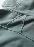 Man wearing sweatpants and the Pieces Basic Program Zip Up Sweatshirt Seafoam Green Blue, close up view of stitching on the back Pieces Basic Program Zip Up Sweatshirt Seafoam - Image 7 | Authenticated at Pieces Los Angeles