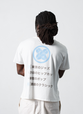 Man wearing Pieces Sounds Tee Shirt White with blue logo and black japanese text, facing away from camera Pieces Sounds Tee White - Image 4 | Authenticated at Pieces Los Angeles