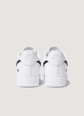 Nike Supreme Air Force 1 White (2025) with black swoosh, full grain leather upper, perforated leather toe panel, DURAPLUSH lining, co-branded footbed, debossed printed logo, Supreme branded laces, back view of both shoes Nike Supreme Air Force 1 White (2025) - Image 2 | Authenticated at Pieces Los Angeles